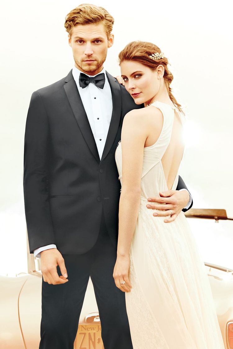 Guy holding his wife close to his Black Michael Kors Berkeley Wedding Tuxedo