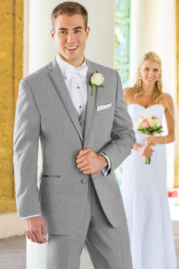 Bride peeking around a corner at the groom wearing the Heather Grey Aspen Wedding Tuxedo